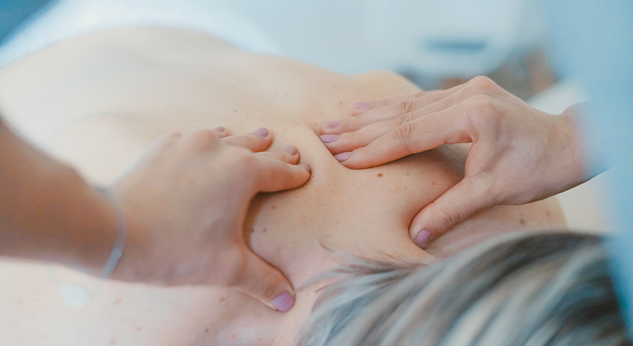 鍼灸師に肩を診てもらう女性