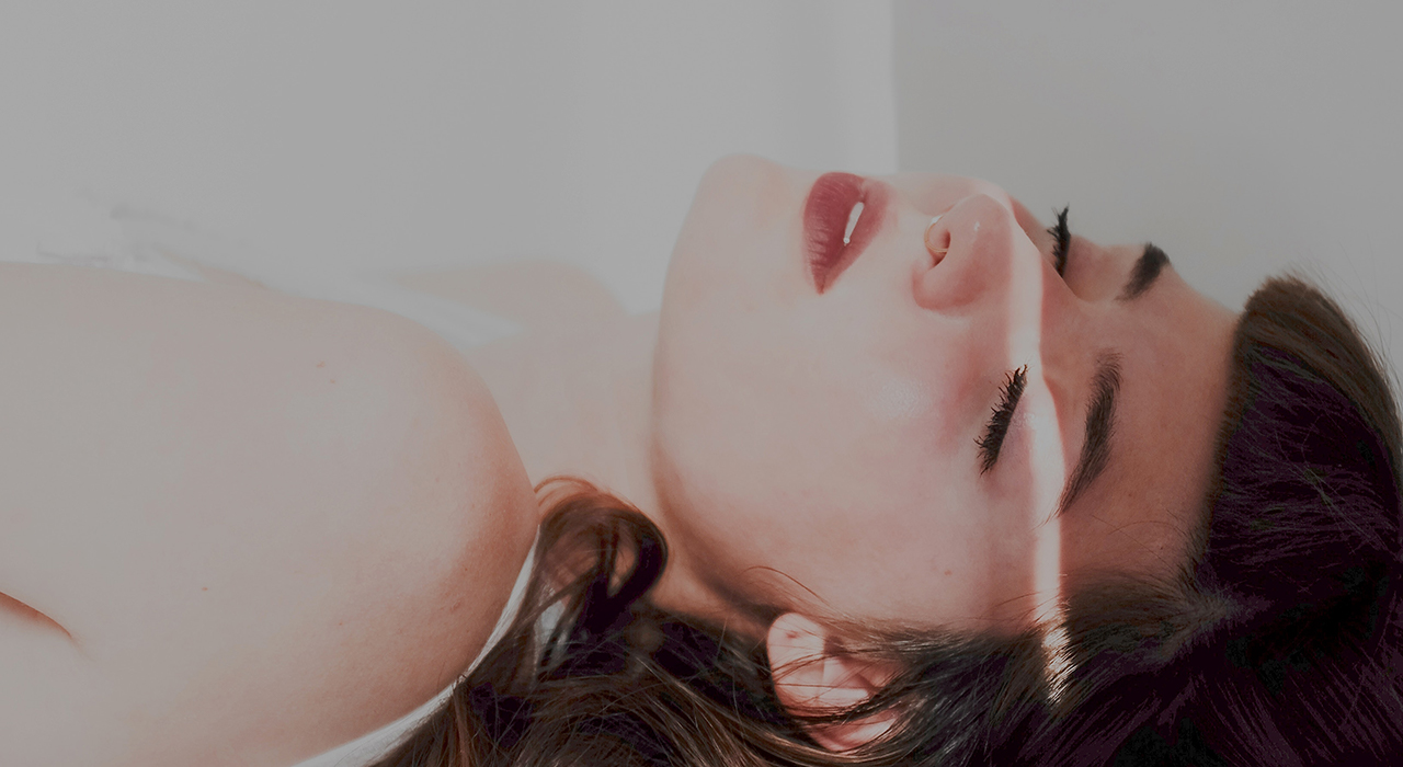 目を閉じて横になる女性